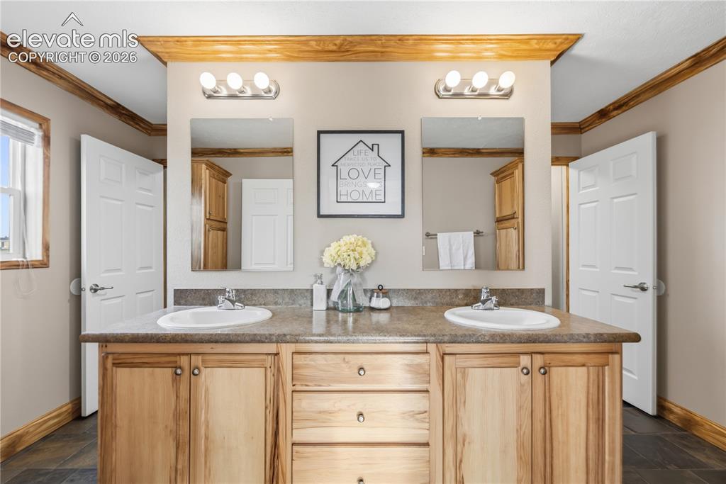 Image 20 of 49: There is a large vanity with dual sinks as you enter the Primary bathroom.