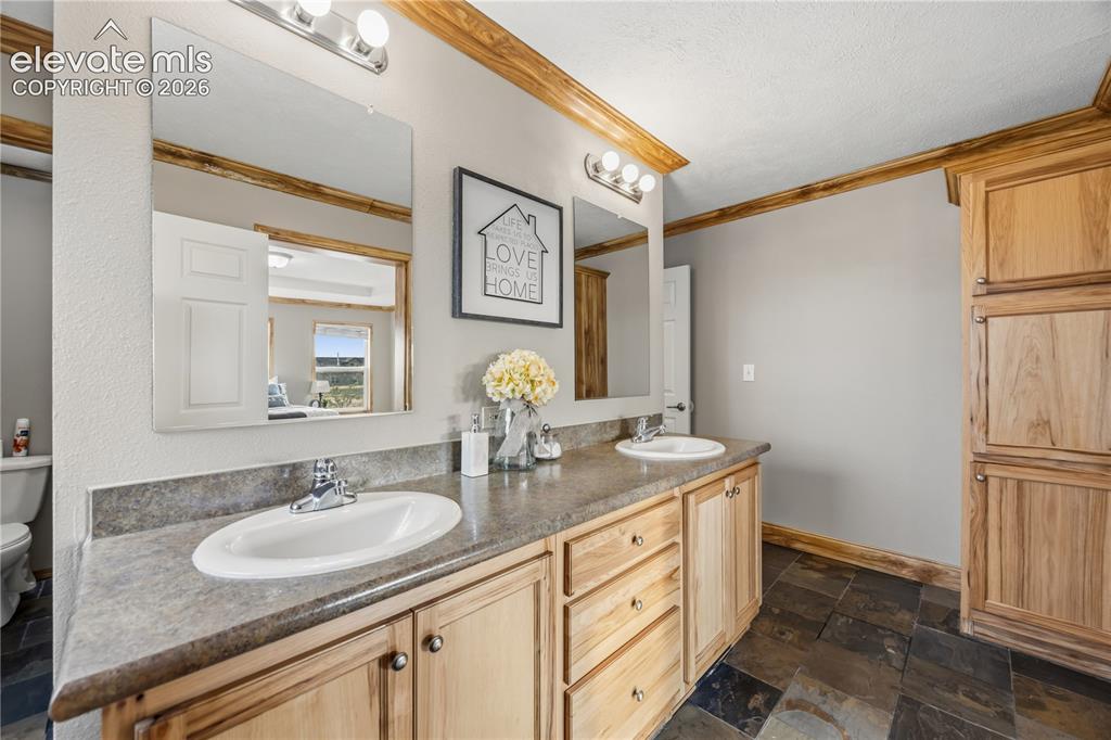 Image 21 of 49: There are large cabinets in each corner near the vanity.