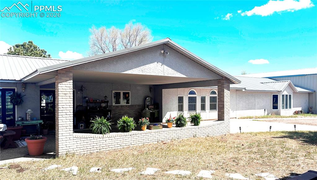 Image 2 of 48: Covered Front Entry with attached Industrial Building/garage at south end.