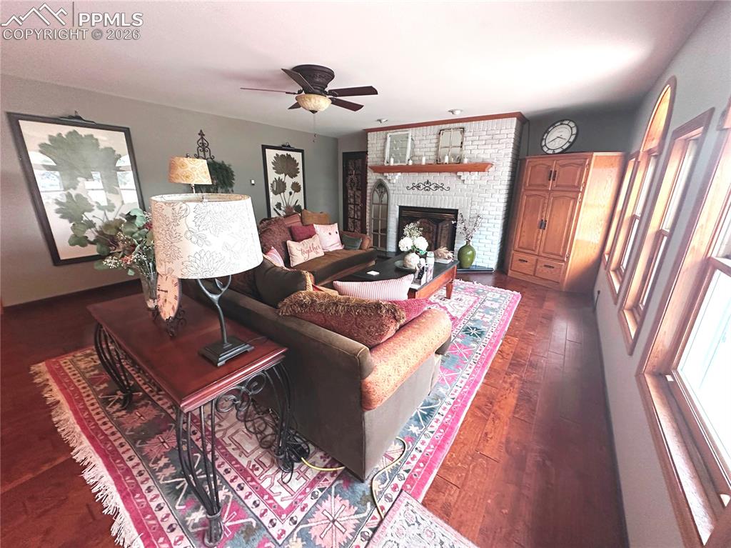 Image 27 of 48: Living room seating area with fireplace at top. Door to great room and 4th