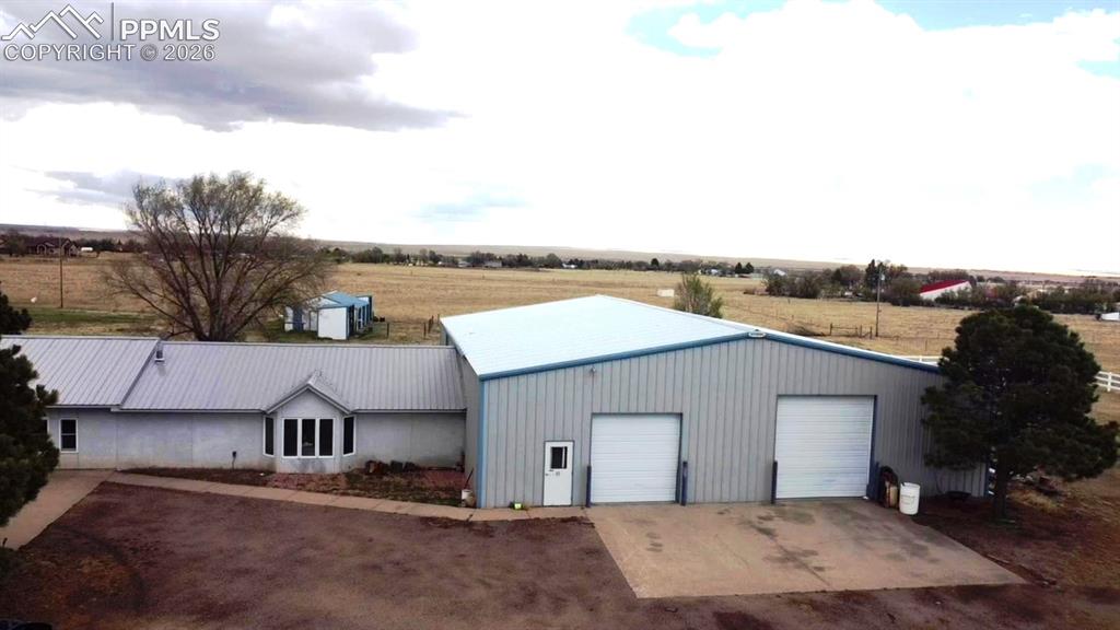 Image 5 of 48: Aerial show the home on the left and massive garage or workshop to the righ