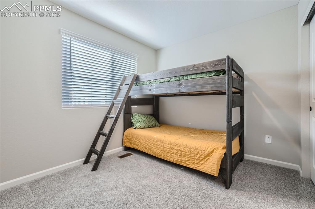 Image 13 of 16: Bedroom featuring light colored carpet and baseboards