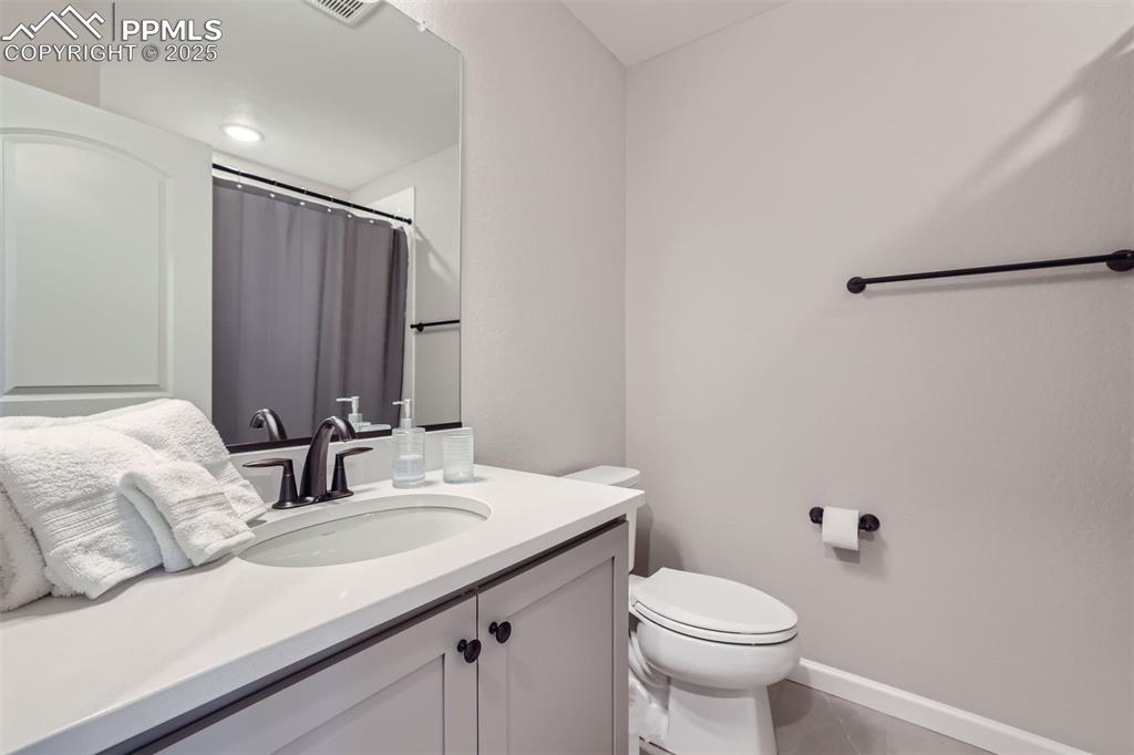Image 14 of 16: Bathroom featuring vanity, tile patterned flooring, and a shower with curta