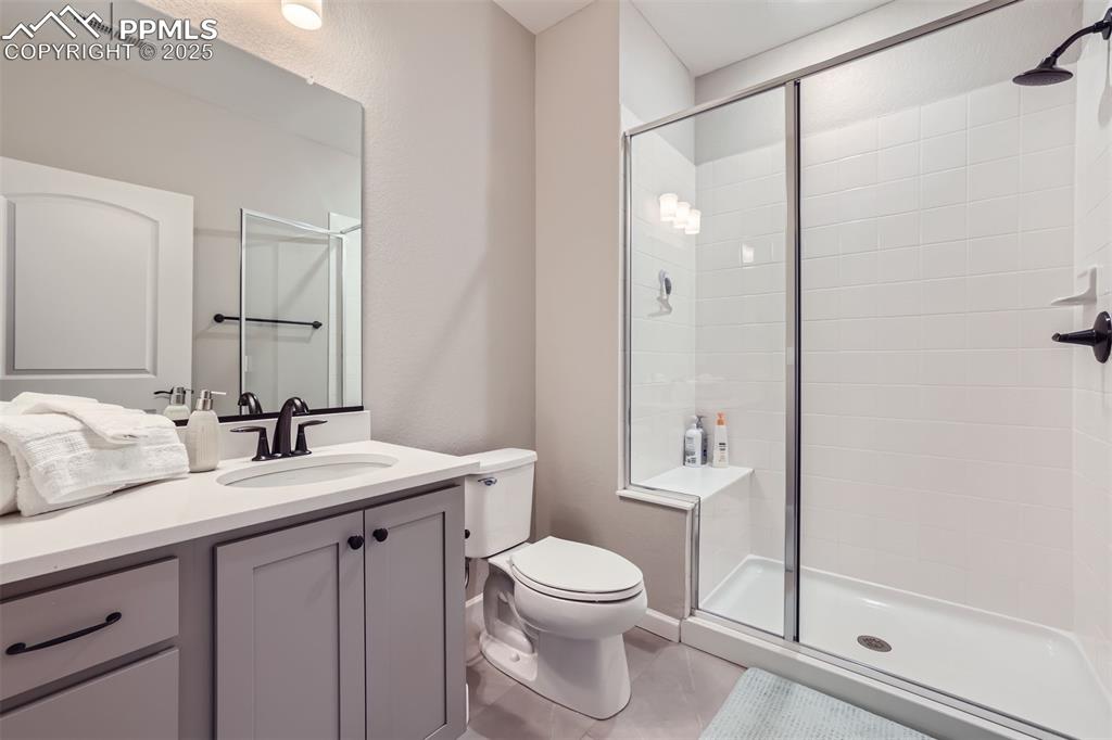 Image 5 of 16: Full bath featuring a stall shower, vanity, and tile patterned floors