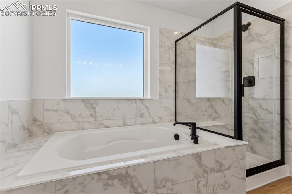 Image 8 of 18: Full bathroom featuring a bath and a marble finish shower