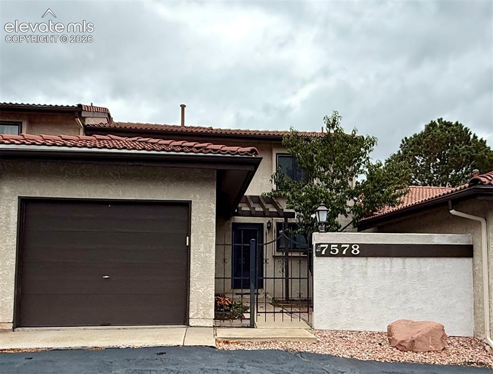 Image 1 of 26: Stucco exterior featuring a tile look roof, single-car garage, enclosed gat