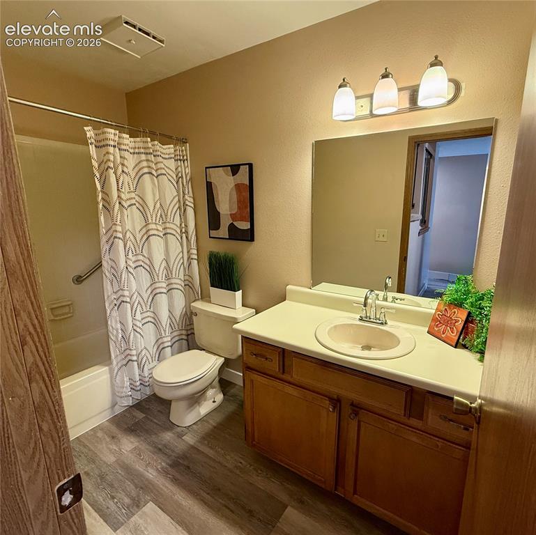 Image 11 of 26: Main level bathroom featuring a wood-finish vanity with a molded countertop