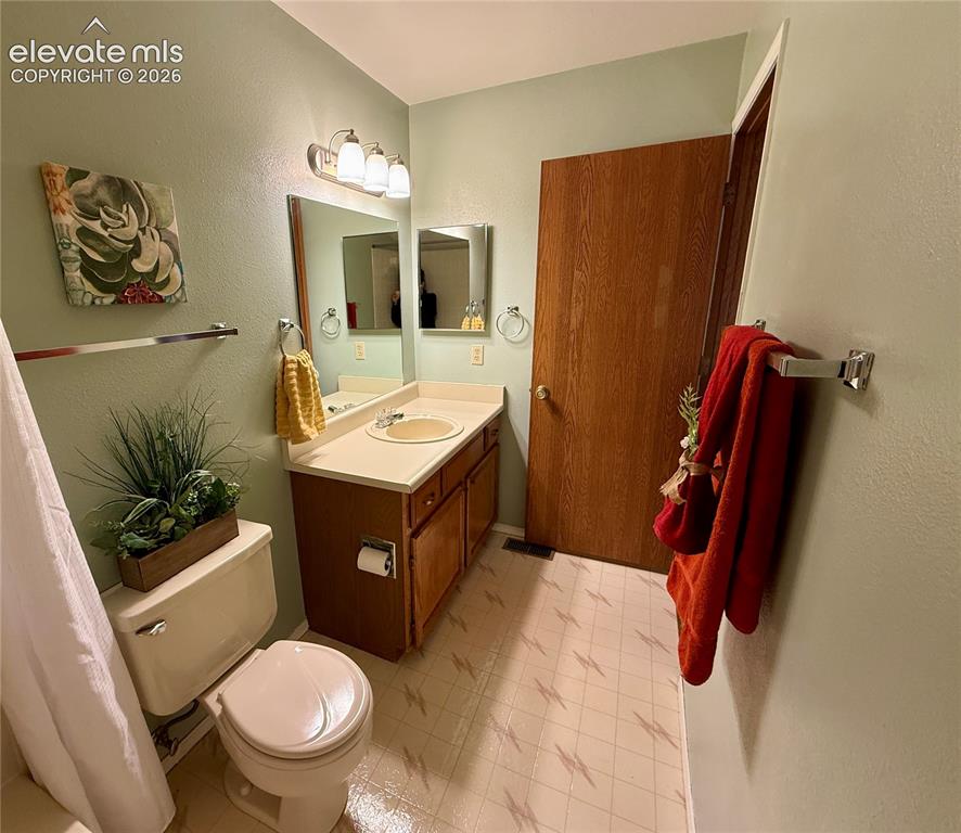 Image 16 of 26: Bathroom featuring a wooden vanity with integrated countertop and sink, thr