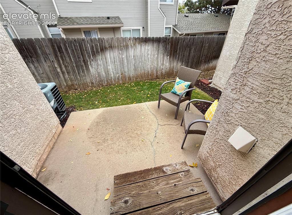 Image 21 of 26: Concrete patio featuring wood-plank steps, and exterior stucco siding