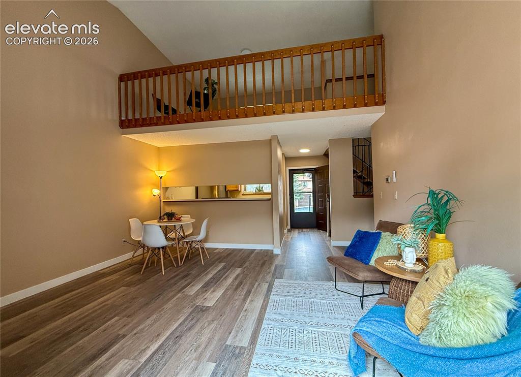 Image 5 of 26: High-vaulted ceilings, wood-look flooring, and a loft area featuring a wood