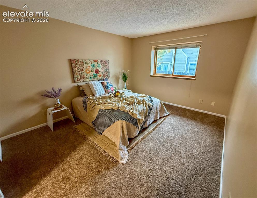 Image 9 of 26: Neutral-toned room featuring wall-to-wall carpeting and a single-pane slidi