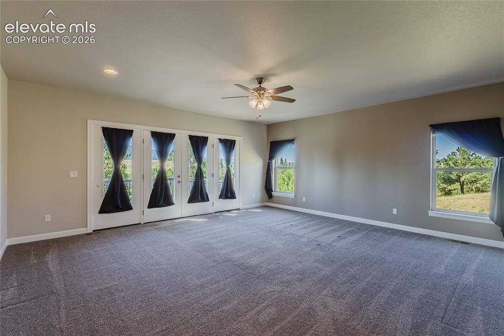 Image 19 of 50: Giant primary bedroom with walk out to deck.