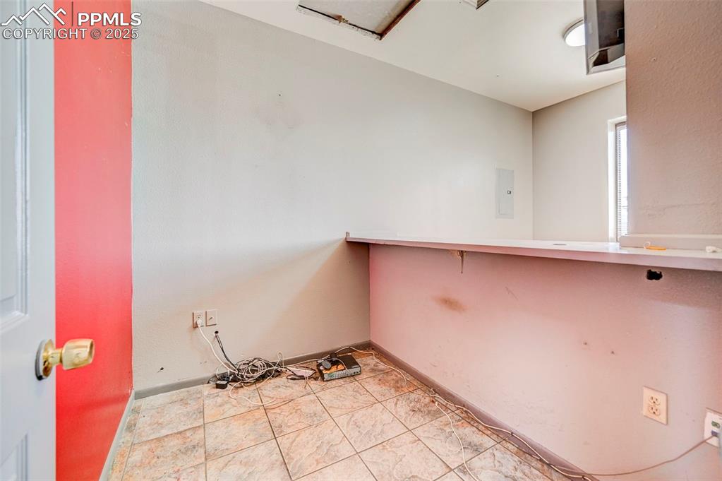 Image 29 of 42: Empty room with electric panel and baseboards
