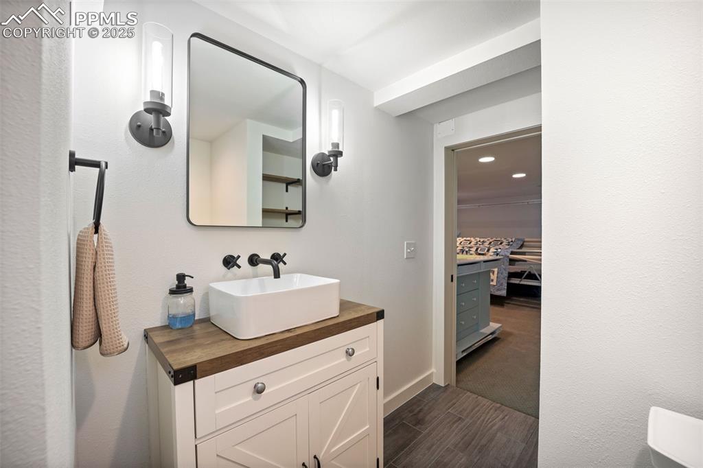 Image 25 of 47: Bathroom featuring vanity, wood finished floors, and recessed lighting