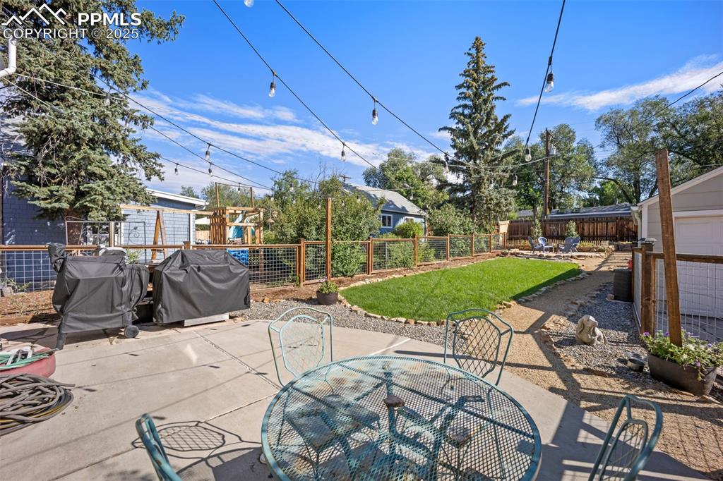 Image 31 of 47: Fenced backyard featuring a patio, outdoor dining space, and grilling area