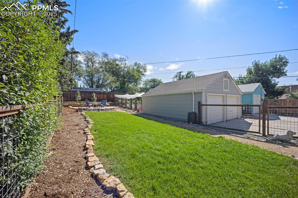 Image 41 of 47: Fenced backyard with an outdoor structure, a patio, and a garage