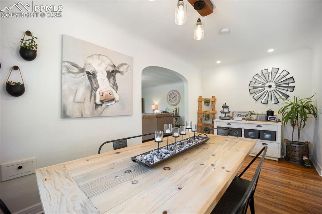 Image 8 of 47: Dining space with arched walkways, recessed lighting, and dark wood-type fl
