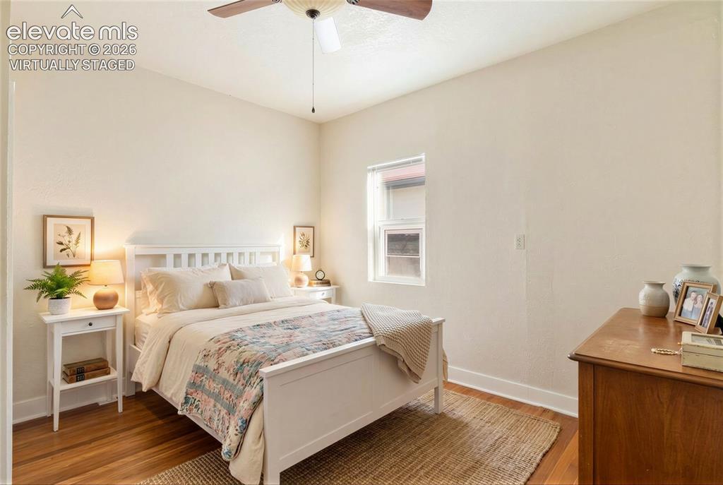 Image 21 of 42: Virtually Staged Hardwood flooring, ceiling fan, single window, white trim,