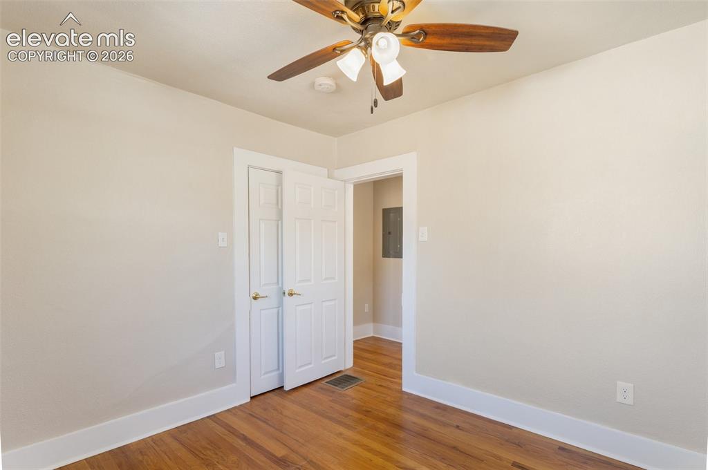 Image 35 of 42: Wood-finish flooring with white trim, a ceiling fan with integrated lightin
