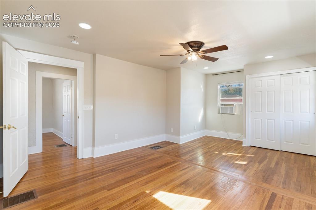 Image 39 of 42: Hardwood flooring, recessed lighting, ceiling fan, white paneled doors, and