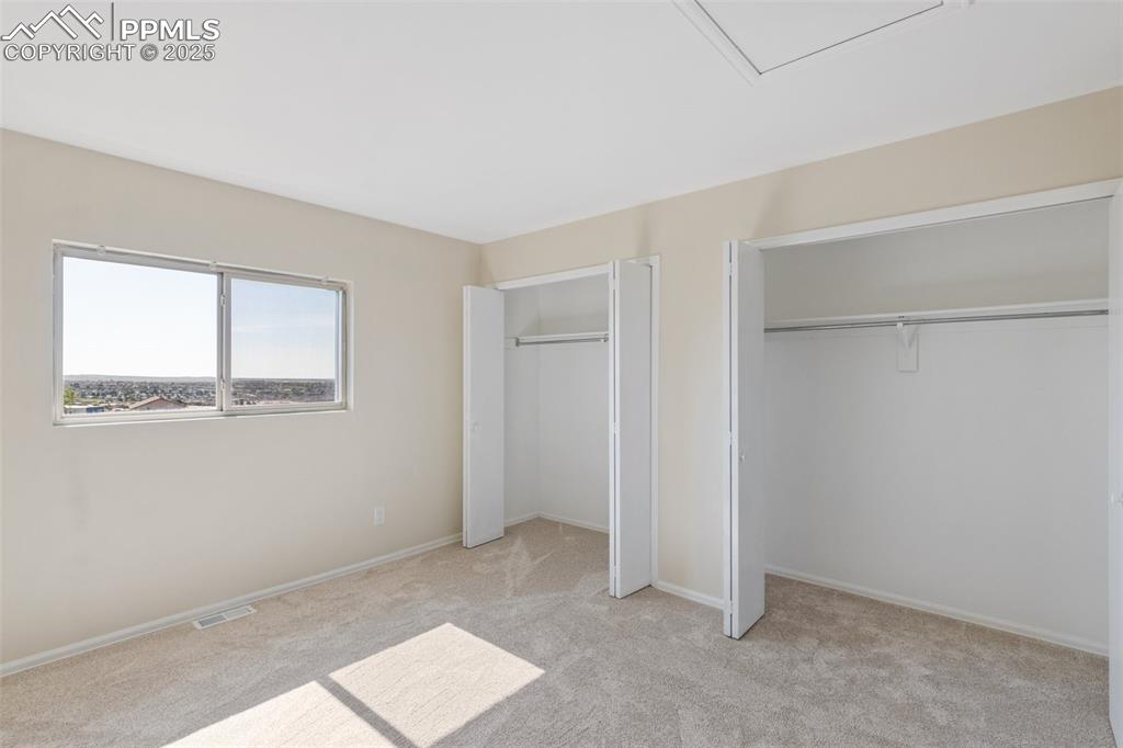 Image 14 of 26: Unfurnished bedroom with multiple closets and light colored carpet
