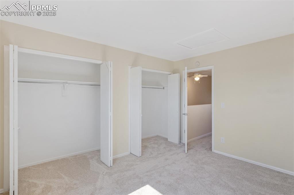 Image 15 of 26: Unfurnished bedroom with carpet, two closets, and attic access