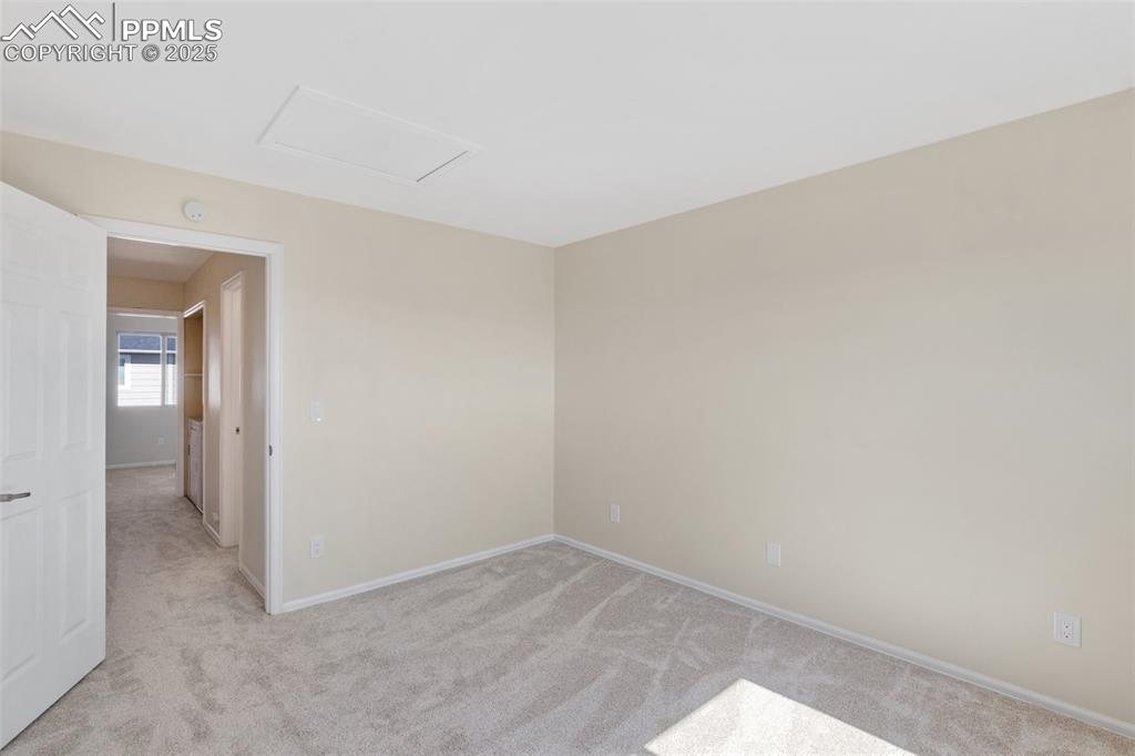 Image 16 of 26: Spare room with light colored carpet and attic access