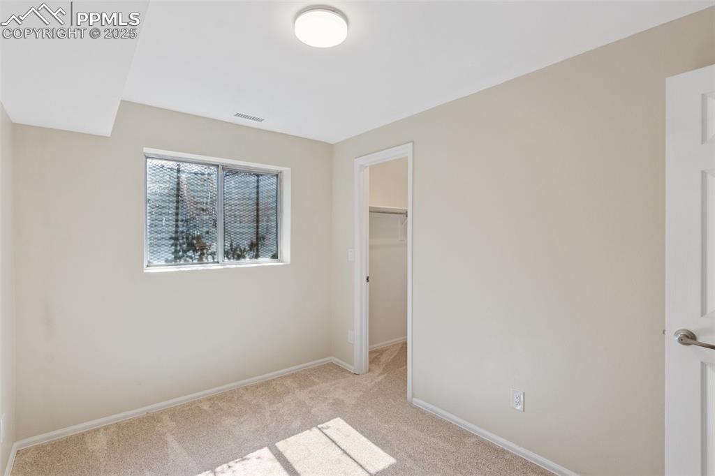 Image 19 of 26: Unfurnished bedroom with light carpet and a walk in closet