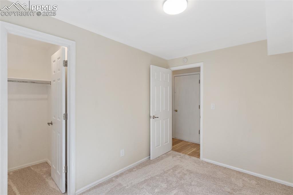 Image 20 of 26: Unfurnished bedroom with light carpet and a spacious closet