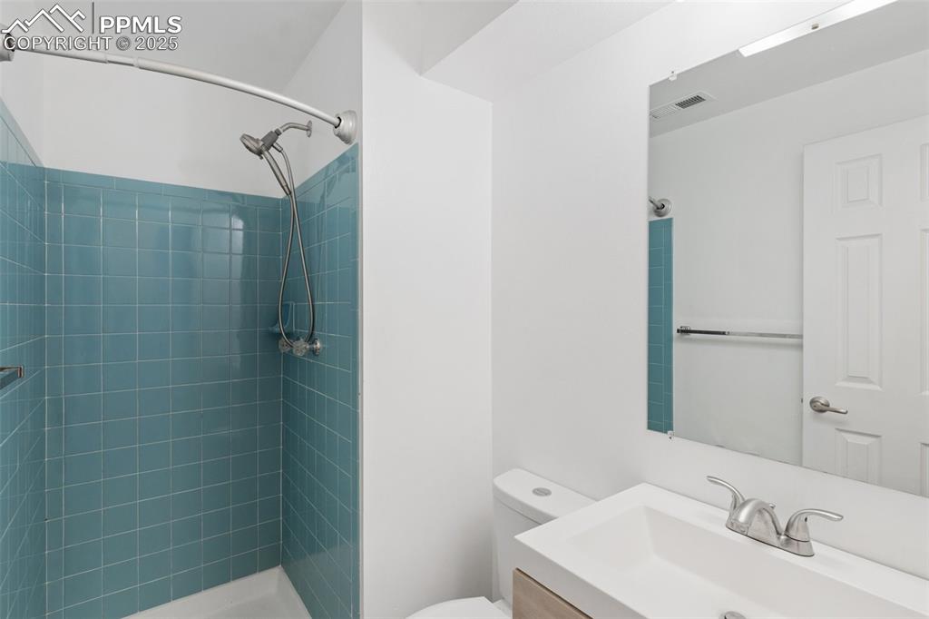 Image 21 of 26: Full bathroom featuring vanity and tiled shower