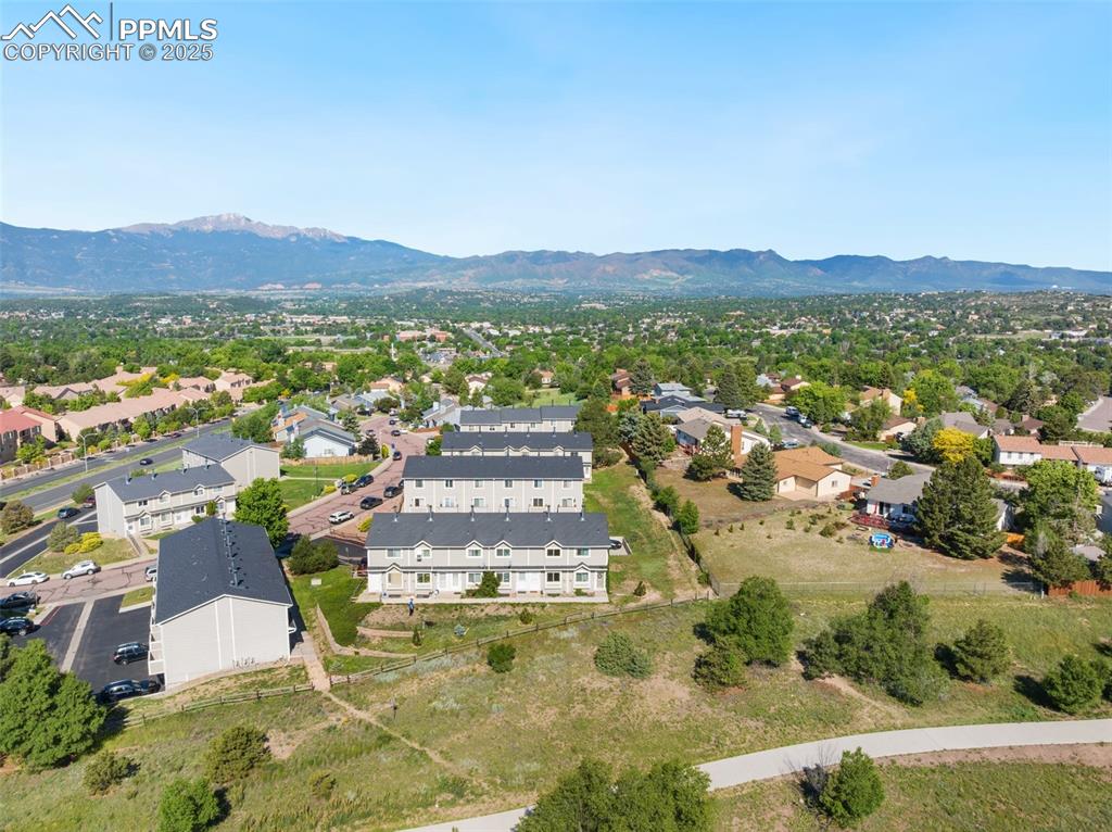 Image 25 of 26: Aerial view of residential area featuring a mountain backdrop
