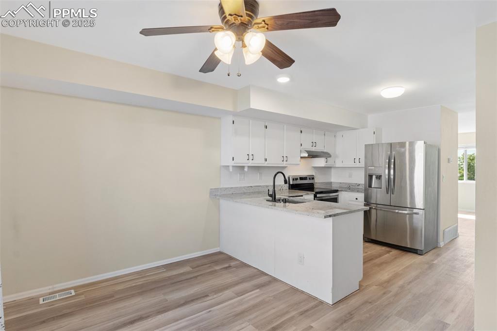 Image 9 of 26: Kitchen featuring appliances with stainless steel finishes, a peninsula, li