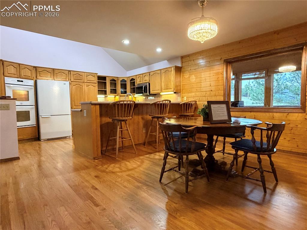 Image 16 of 45: Dining space with vaulted ceiling, recessed lighting, light wood finished f