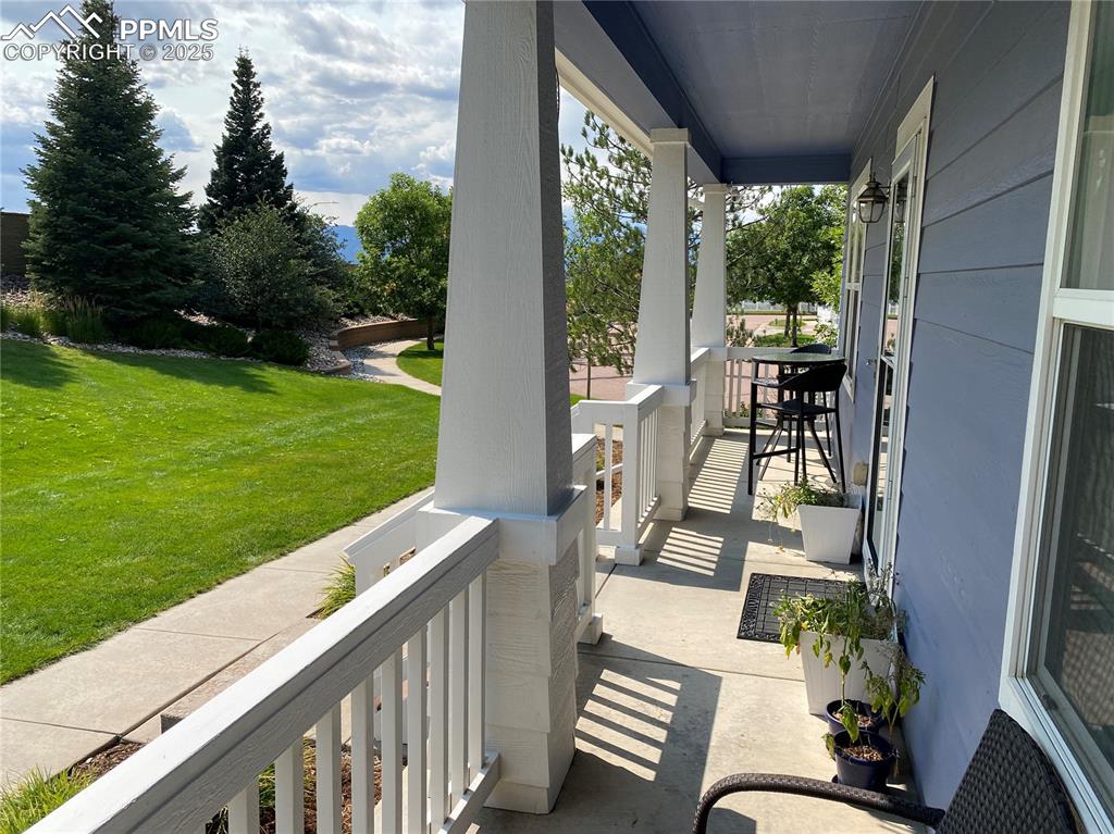 Image 12 of 41: This cozy covered porch provides a relaxing spot for morning coffee, casual