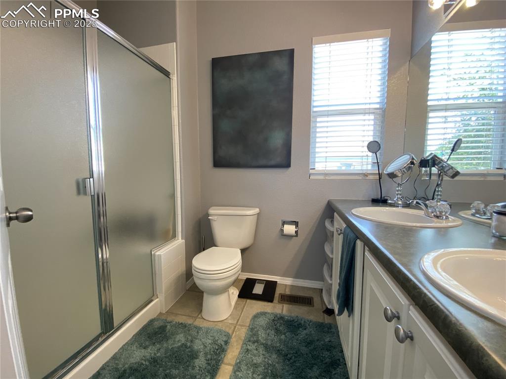 Image 26 of 41: The primary suite’s bathroom boasts dual vanities and a contemporary free-s