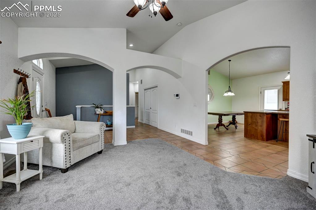 Image 13 of 47: Living area featuring light tile patterned floors, light colored carpet, a 