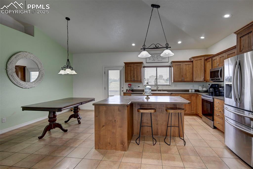 Image 19 of 47: Kitchen with stainless steel appliances, a kitchen breakfast bar, decorativ
