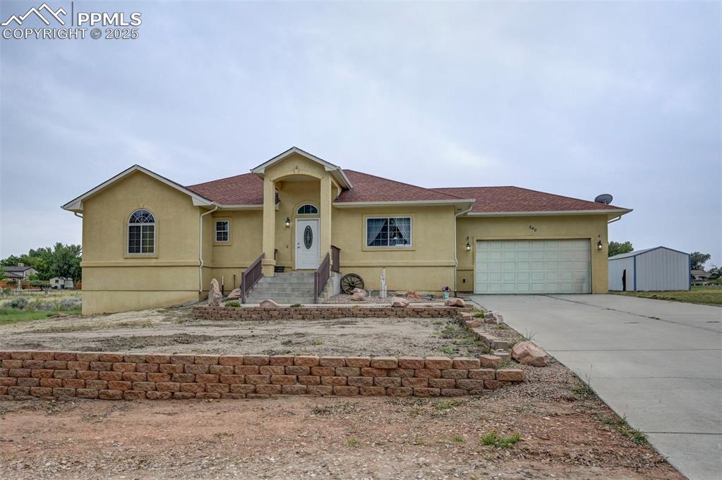 Image 2 of 47: View of front of house with stucco siding, driveway, and an attached garage