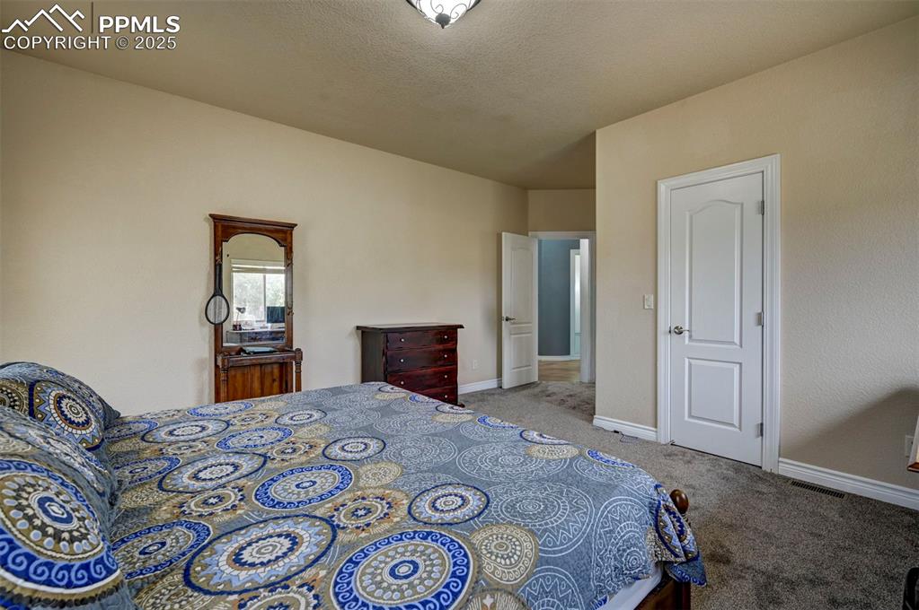 Image 30 of 47: Bedroom with carpet floors and a textured ceiling