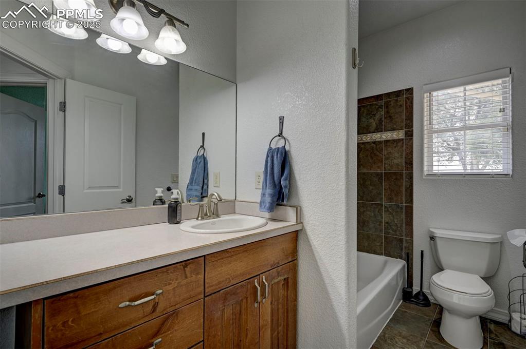 Image 31 of 47: Bathroom featuring a textured wall, vanity, and bathtub / shower combinatio