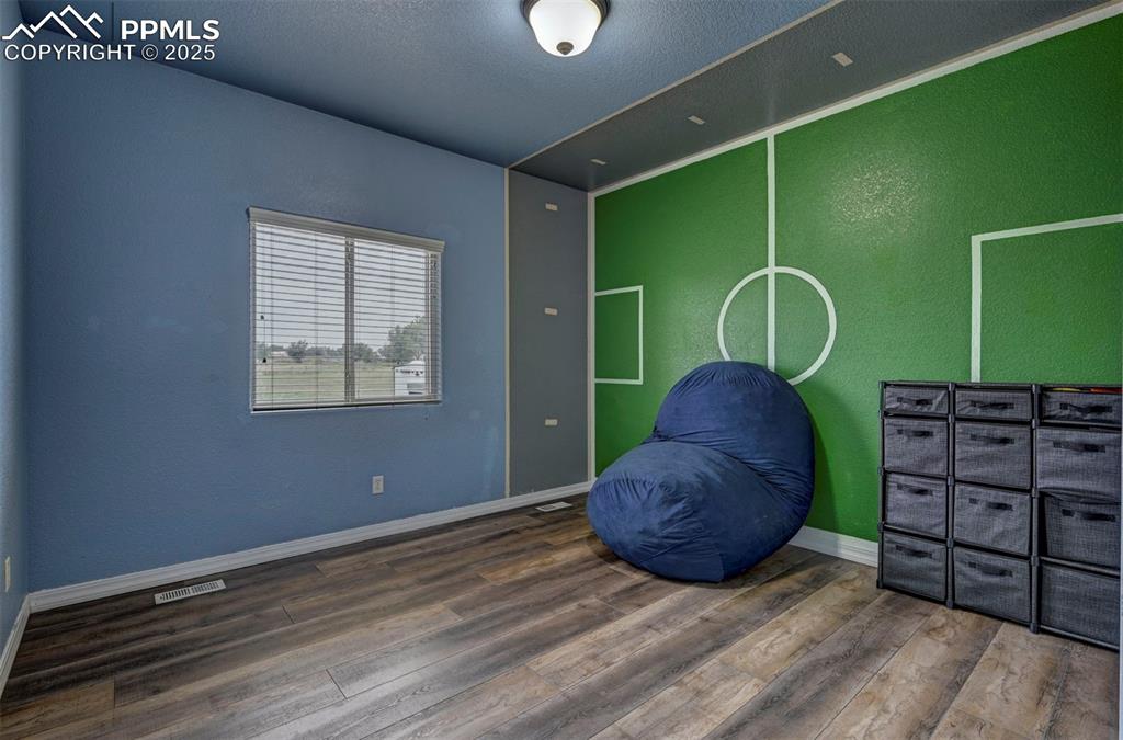 Image 33 of 47: Unfurnished room with wood finished floors, a textured wall, and a textured