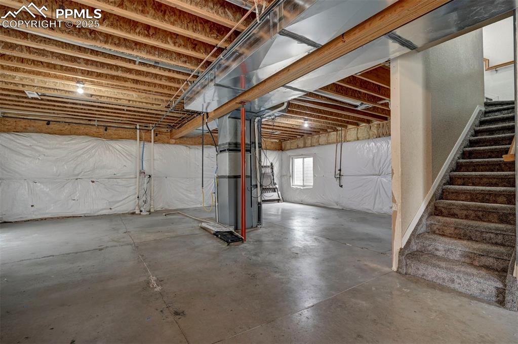 Image 35 of 47: Below grade area featuring stairway and heating unit