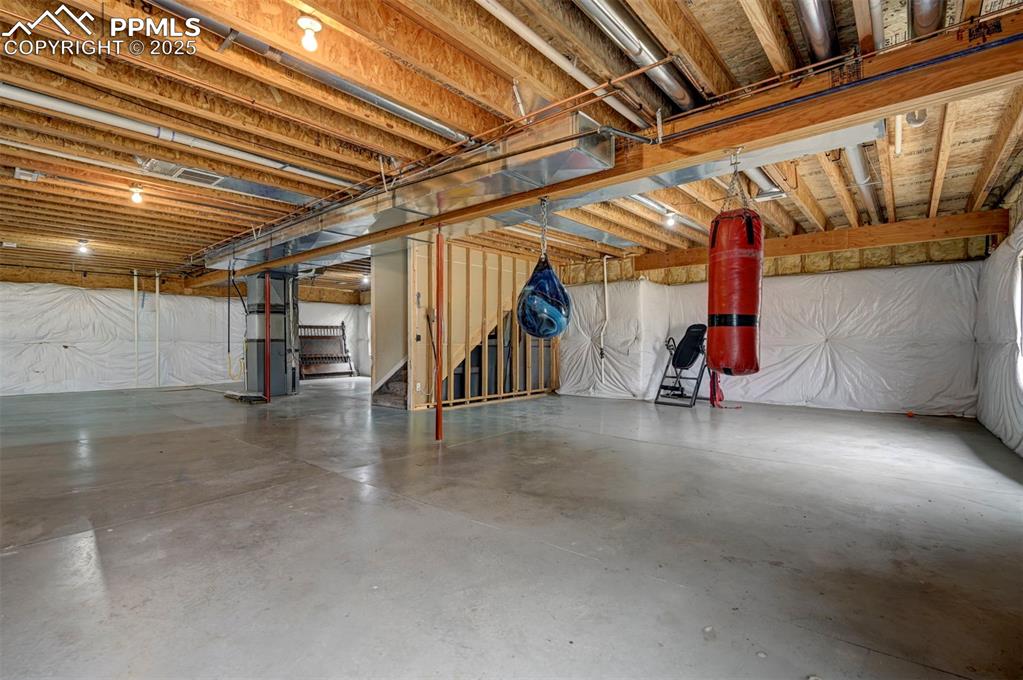 Image 36 of 47: Unfinished basement with heating unit and a central vacuum unit