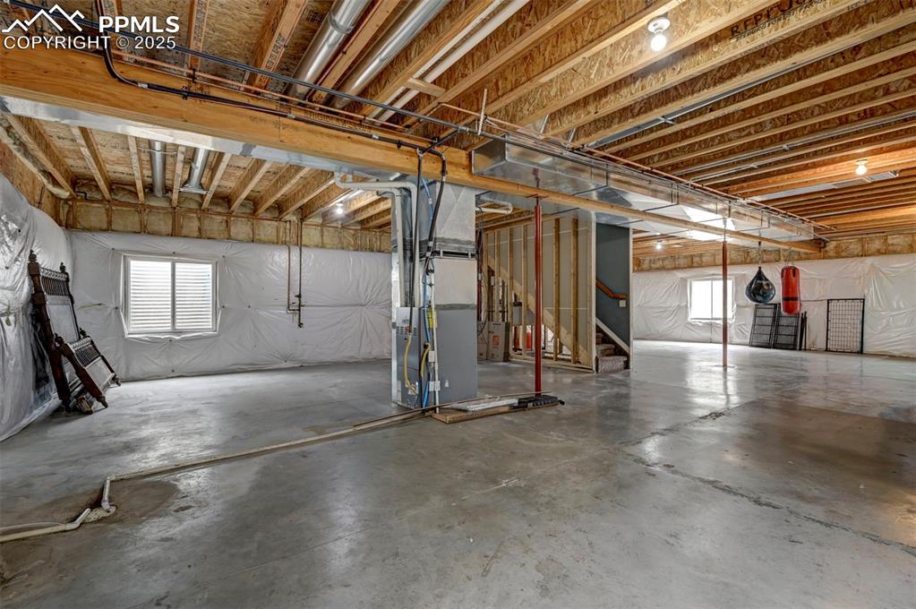 Image 37 of 47: Below grade area featuring plenty of natural light, heating unit, and stair