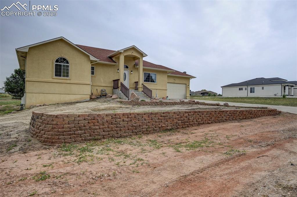 Image 4 of 47: View of front facade featuring stucco siding, driveway, and a garage