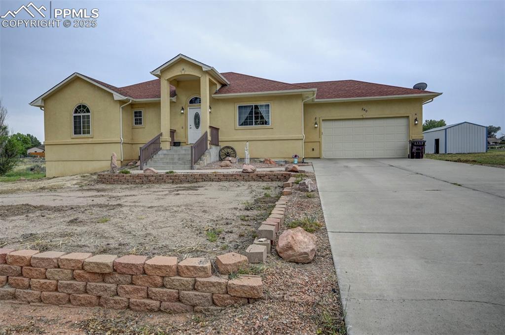 Image 5 of 47: View of front of house featuring stucco siding, driveway, roof with shingle