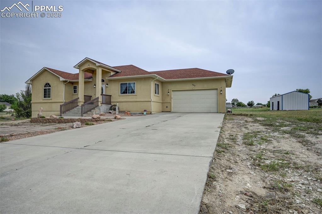 Image 8 of 47: View of front of property featuring stucco siding, concrete driveway, a gar