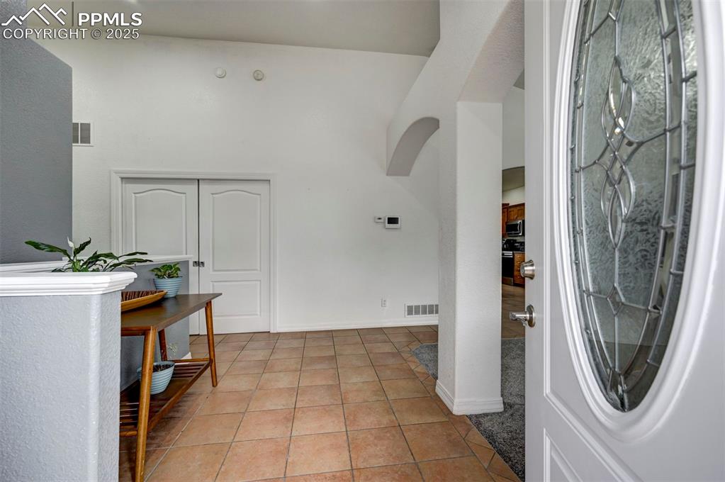 Image 9 of 47: Entrance foyer featuring light tile patterned floors and arched walkways