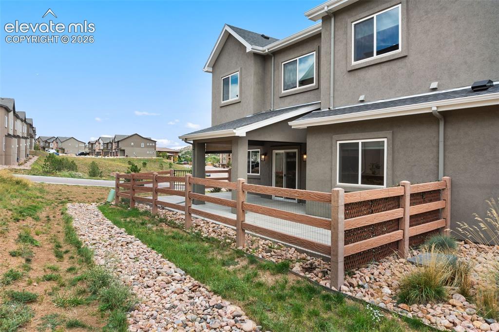 Image 10 of 43: Stucco exterior with multiple windows, covered patio, sliding glass door, a