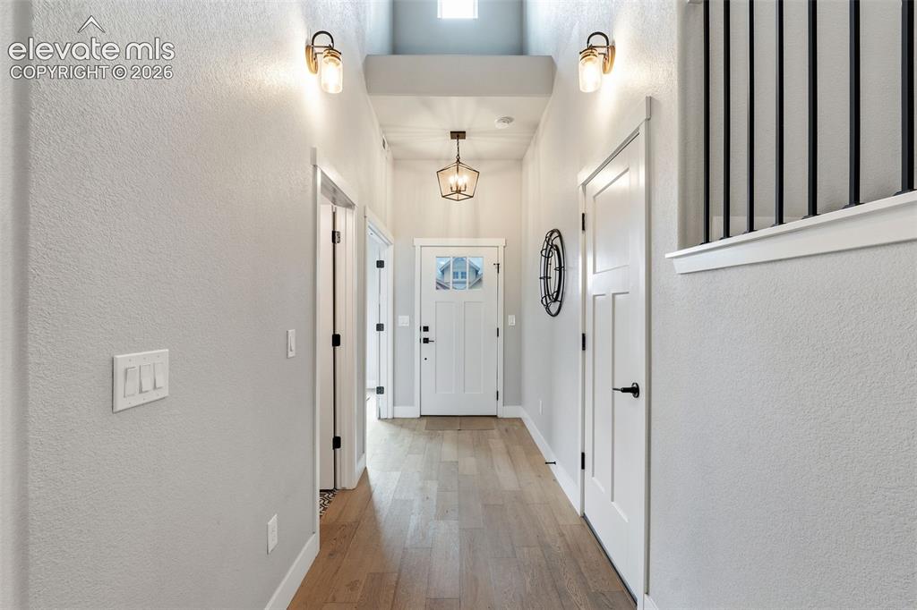 Image 13 of 43: Vaulted ceiling with skylight, wood-finish flooring, white paneled doors, b
